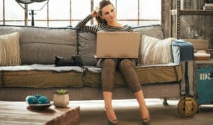 Thoughtful young woman with dslr photo camera using laptop in loft apartment Thoughtful young woman with dslr photo camera using laptop in loft apartment